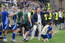 Tréner Weiss (v popredí v rozbehu) prežíva posledné sekundy stretnutia v odvetnom stretnutí play-off Ligy majstrov ŠK Slovan Bratislava – FC Midtjylland. FOTO: TASR/P. Neubauer