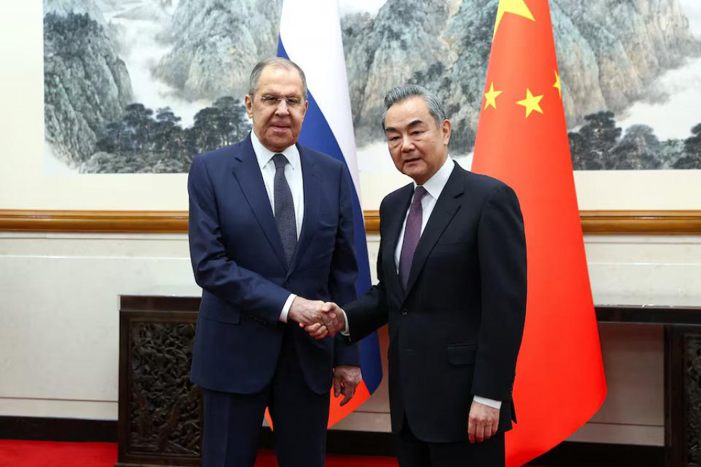 Ruský minister zahraničných vecí Sergej Lavrov si podáva ruku s čínskym ministrom zahraničných vecí Wang Yi počas stretnutia v Pekingu. FOTO: Reuters