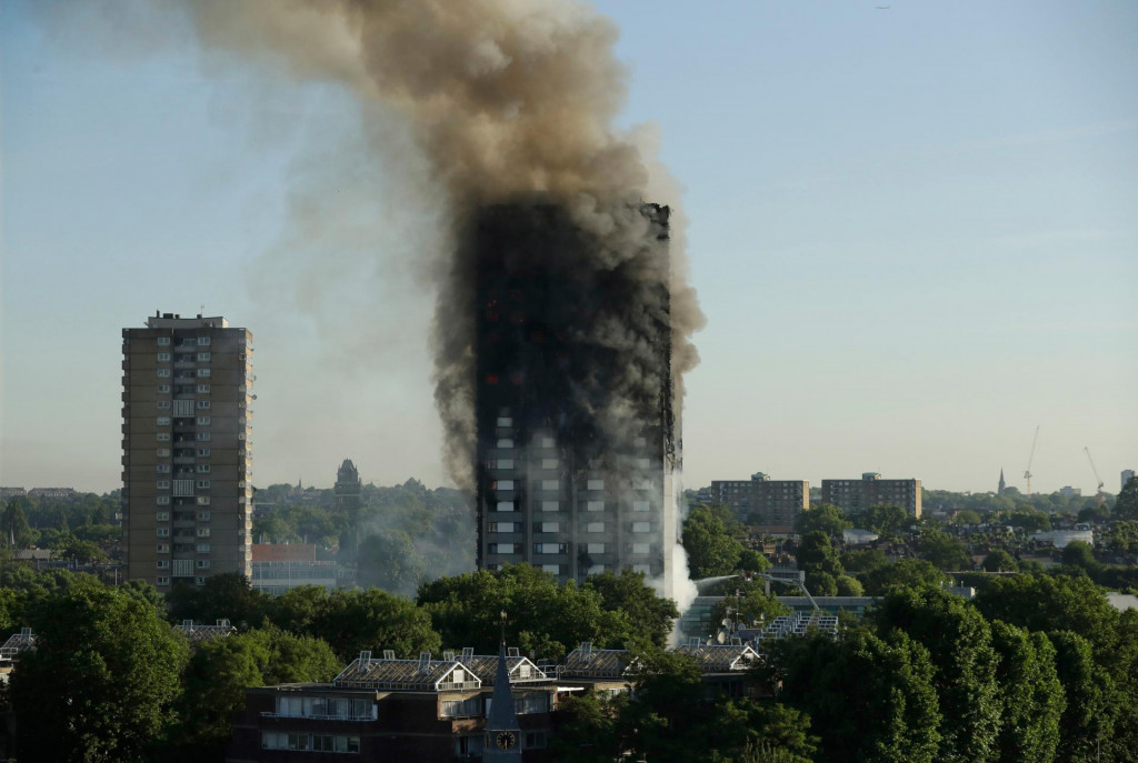 Na archívnej snímke zo 14. júna 2017 dym stúpa z 24-podlažnej výškovej obytnej budovy Grenfell Tower v Londýne. FOTO: TASR/AP