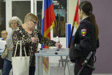 Žena vhadzuje svoj hlasovací lístok do volebnej urny vo volebnej miestnosti umiestnenej v škole počas trojdňových regionálnych a komunálnych volieb v ruskom Petrohrade. FOTO: TASR/AP