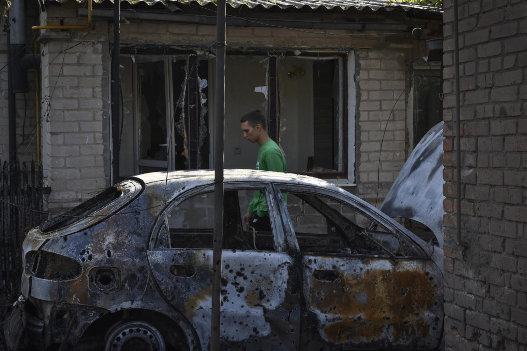 Muž prechádza okolo zničeného auta po ruskom raketovom útoku v dedine Malokaterynivka, v Záporožskej oblasti na juhu Ukrajiny. FOTO: TASR/AP