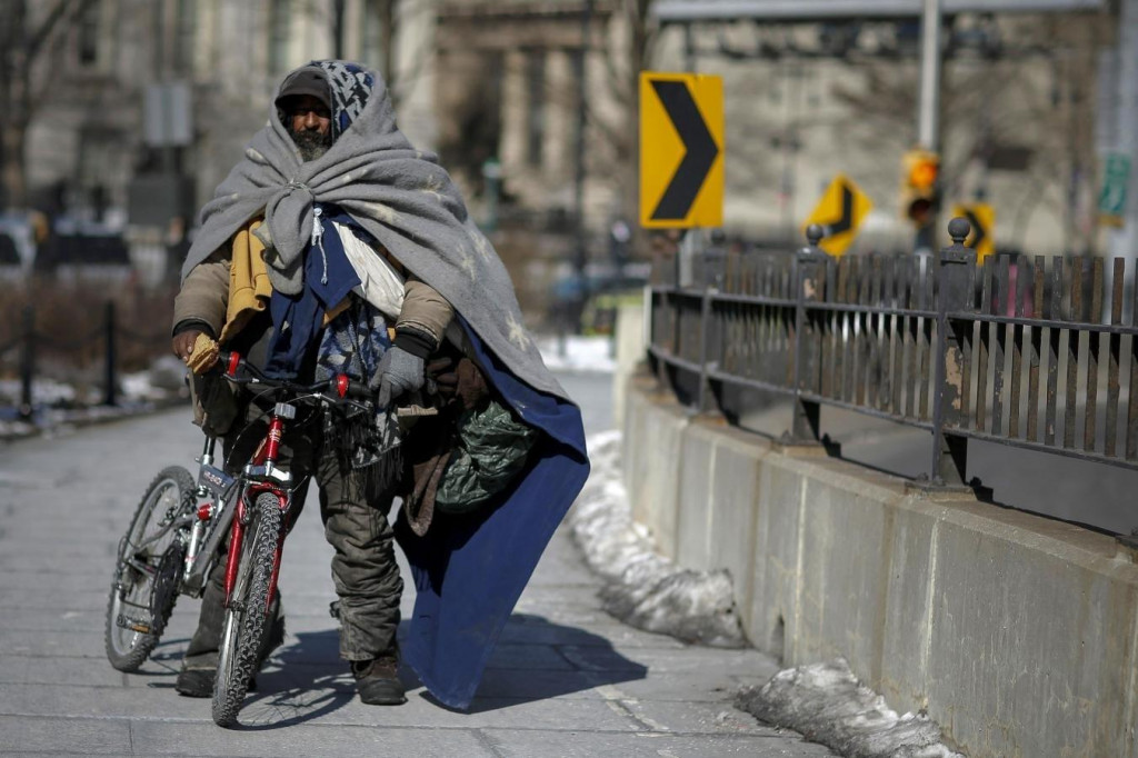 Muž bez domova prechádza Brooklynským mostom. Nedostatočné kapacity sa zatiaľ riešia zriadením veľkokapacitného tábora z bývalého letiska na okraji Brooklynu. FOTO: Reuters