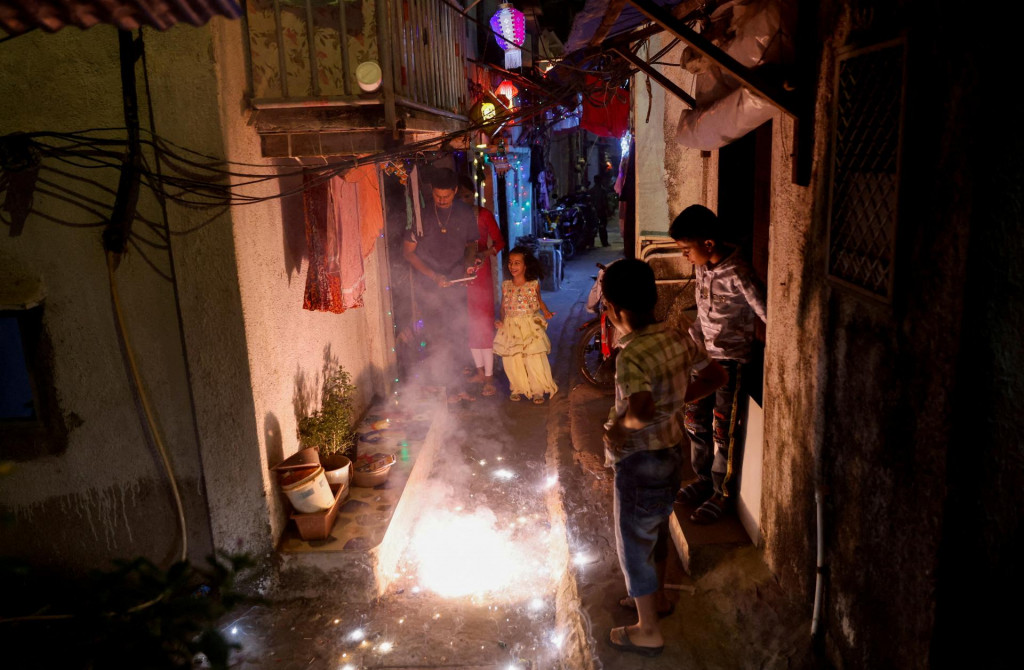 Ľudia sledujú, ako horia petardy počas Díválí, hinduistického festivalu svetiel. FOTO: Reuters