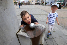 Na snímke deti pri zdroji pitnej vody počas tohtoročných letných horúčav v Banskej Bystrici.

FOTO: TASR/J. Krošlák