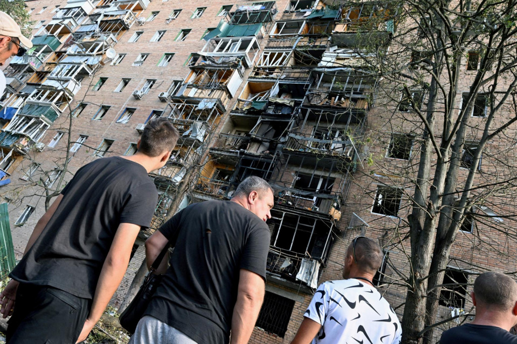 Ľudia sa zhromažďujú na nádvorí viacposchodovej obytnej budovy, ktorú podľa miestnych úradov zasiahli úlomky zo zničenej ukrajinskej rakety ruskom Kursku (11. augusta 2024). Reuters/Kommersant Photo