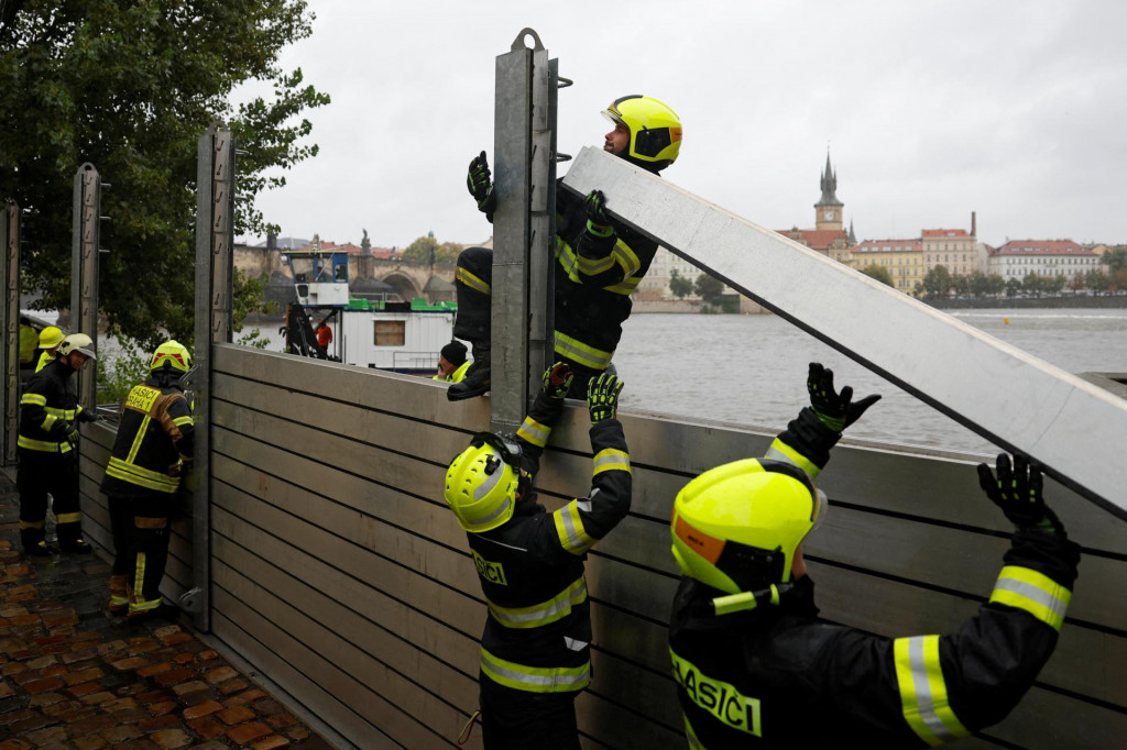 Hasiči montujú vodnú bariéru v stredovekej štvrti Kampa, aby zabránili rozliatiu povodňovej vody do ulíc v Prahe. FOTO: Reuters