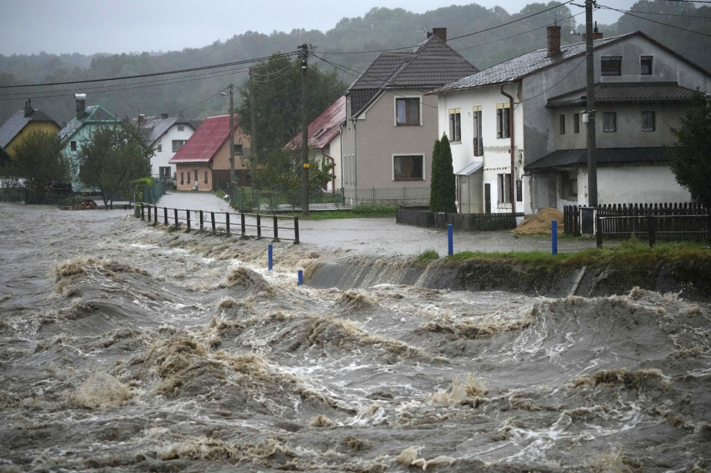 Rieka Belá preteká pri povodniach v Mikuloviciach popri domoch. FOT: TASR/AP