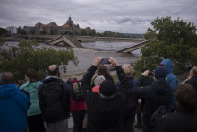 Ľudia sa pozerajú na čiastočne zrútený most Carolabrücke na rieke Labe, ktorej hladina stúpa v dôsledku záplav v meste Drážďany v spolkovej krajine Sasko. FOTO: TASR/AP