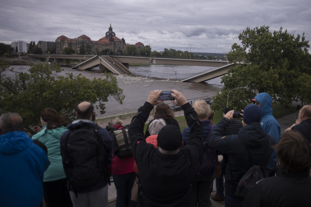 Ľudia sa pozerajú na čiastočne zrútený most Carolabrücke na rieke Labe, ktorej hladina stúpa v dôsledku záplav v meste Drážďany v spolkovej krajine Sasko. FOTO: TASR/AP