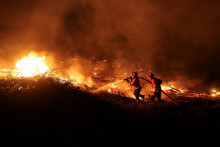 Hasiči sa pokúšajú uhasiť lesný požiar v Canas de Senhorim v Portugalsku. FOTO: Reuters