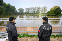 Policajti hliadkujú v zaplavenej bratislavskej mestskej časti Devínska Nová Ves. FOTO: TASR/Jaroslav Novák