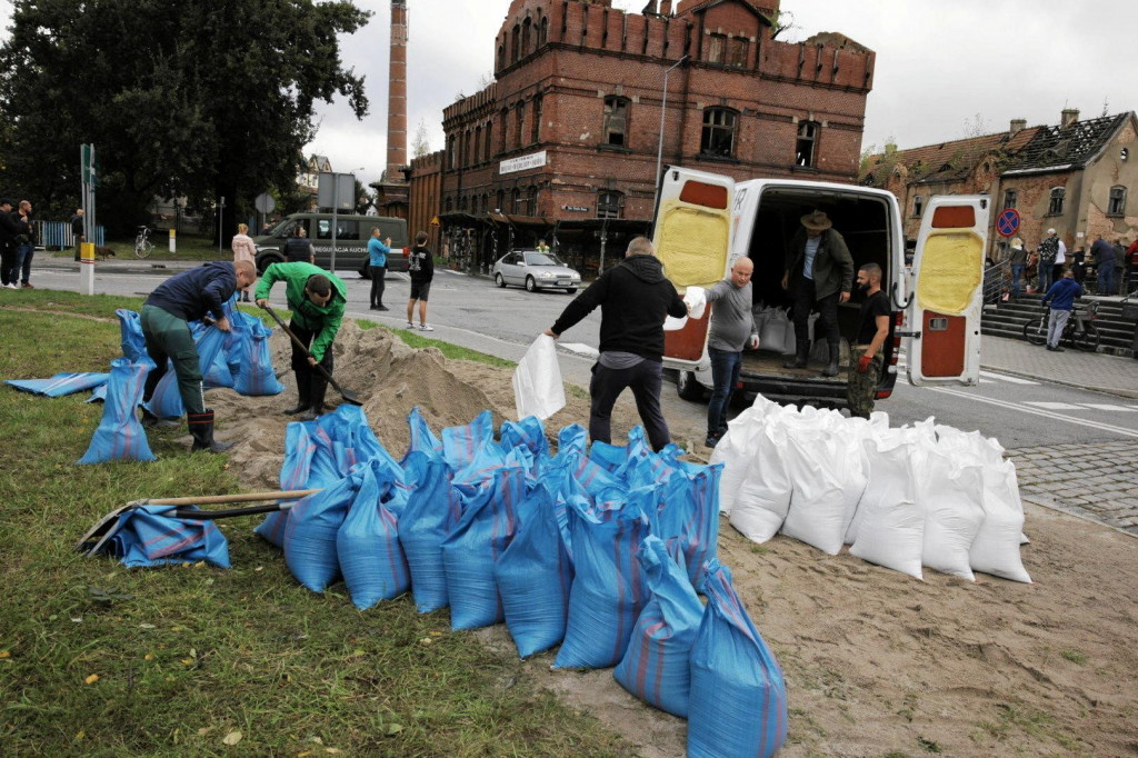 Muži pracujú na zabezpečení oblasti vrecami s pieskom počas príprav na povodeň v poľskej Nise. FOTO: Reuters/Lukasz Cynalewski