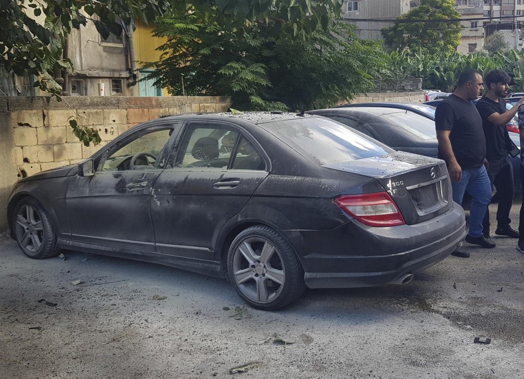 Policajti kontrolujú poškodené auto po tom, čo v ňom vybuchlo vreckové zariadenie tzv. pager v meste Sidon na juhu Libanonu. FOTO: TASR/AP