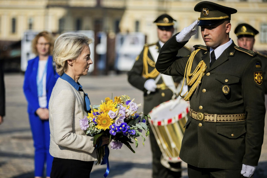 Predsedníčka Európskej komisie Ursula von der Leyenová drží kyticu kvetov, ktorú umiestni na stenu na pamiatku padlých ukrajinských vojakov vo vojne s Ruskom v Kyjeve. FOTO: TASR/AP