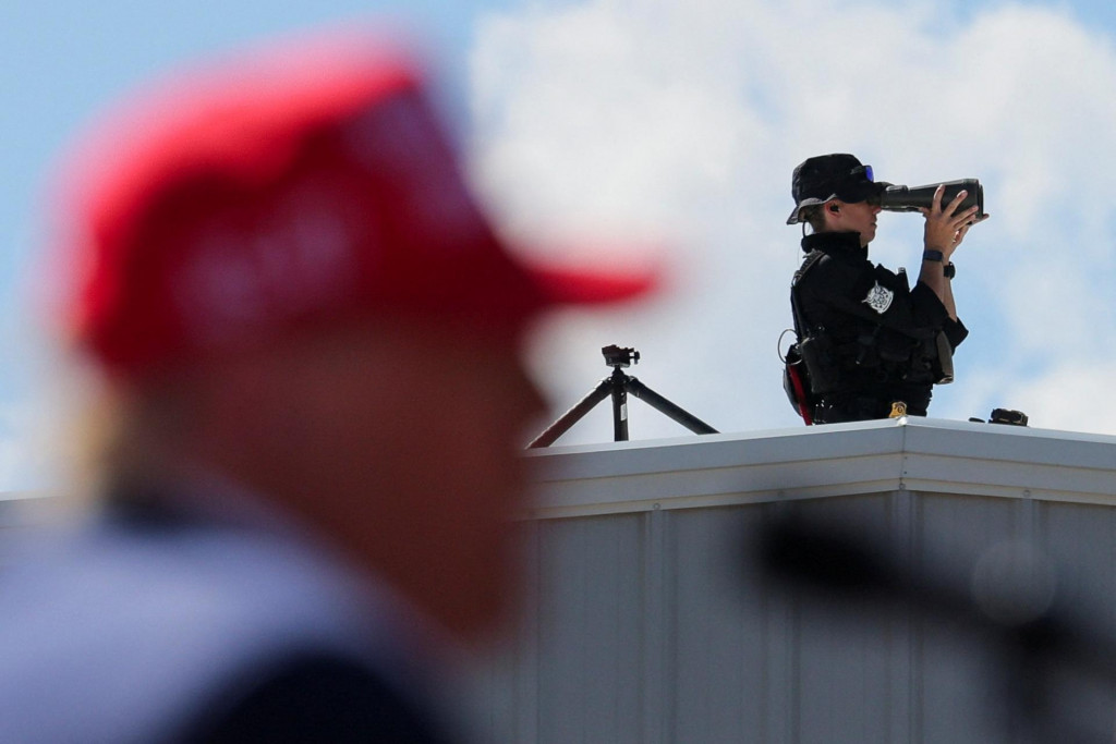 Člen bezpečnostných síl zo strechy dohliada na Donalda Trumpa. FOTO: Reuters