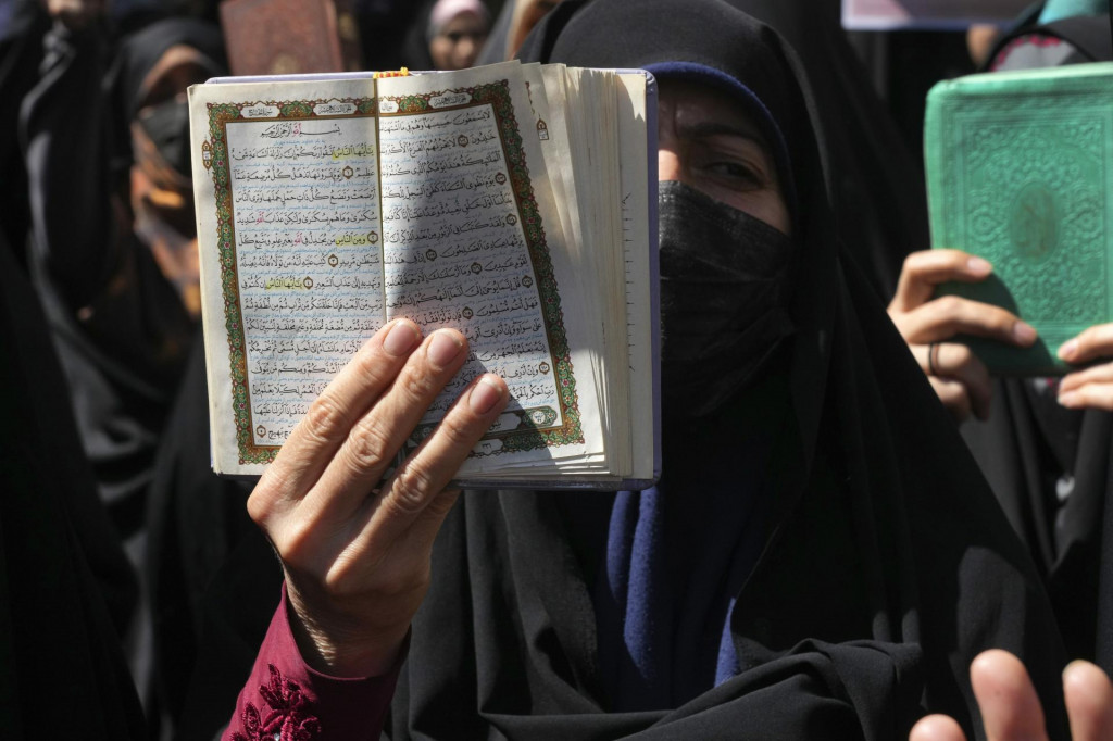 Demonštrant drží kópiu Koránu, svätej knihy islamu, počas protestu proti páleniu Koránu vo Švédsku. FOTO: TASR/AP