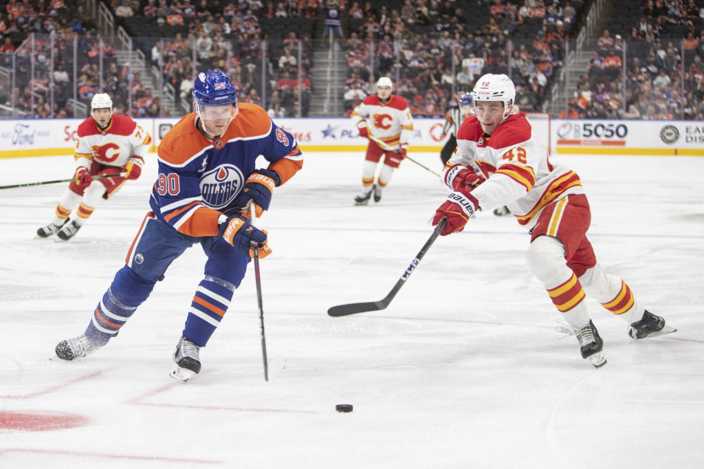 Slovenský útočník Calgary Samuel Honzek a hráč Edmontonu Corey Perry v prípravnom zápase zámorskej hokejovej NHL Edmonton Oilers - Calgary Flames. FOTO: TASR/AP