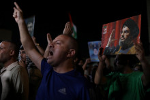 Demonštranti gestikulujú, keď nesú fotografie libanonského vodcu Hizballáhu Sayyeda Hasana Nasralláha počas protestu po jeho zabití pri izraelskom nálete. FOTO: Reuters