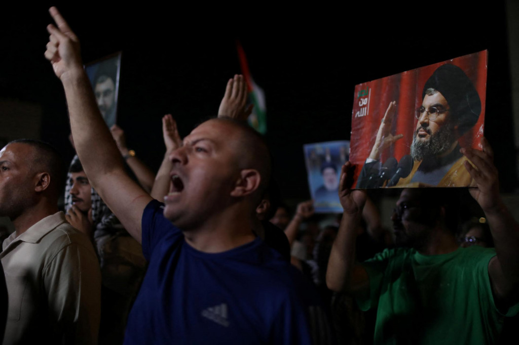 Demonštranti gestikulujú, keď nesú fotografie libanonského vodcu Hizballáhu Sayyeda Hasana Nasralláha počas protestu po jeho zabití pri izraelskom nálete. FOTO: Reuters