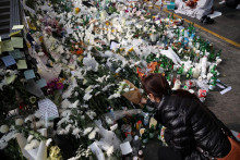 Osoba pokladá kvetinu ako poctu obetiam blízko scény tlačenice davu, ku ktorej došlo počas Halloweenskych slávností v Soule. FOTO: Reuters