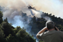 Vrtuľník hasí lesný požiar pri dedine Helidori neďaleko Korintu v Grécku. FOTO: Reuters