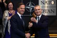 Jens Stoltenberg si podáva ruku s novým generálnym tajomníkom NATO Markom Ruttem na zasadnutí Severoatlantickej rady v sídle Aliancie v Bruseli. FOTO: Reuters