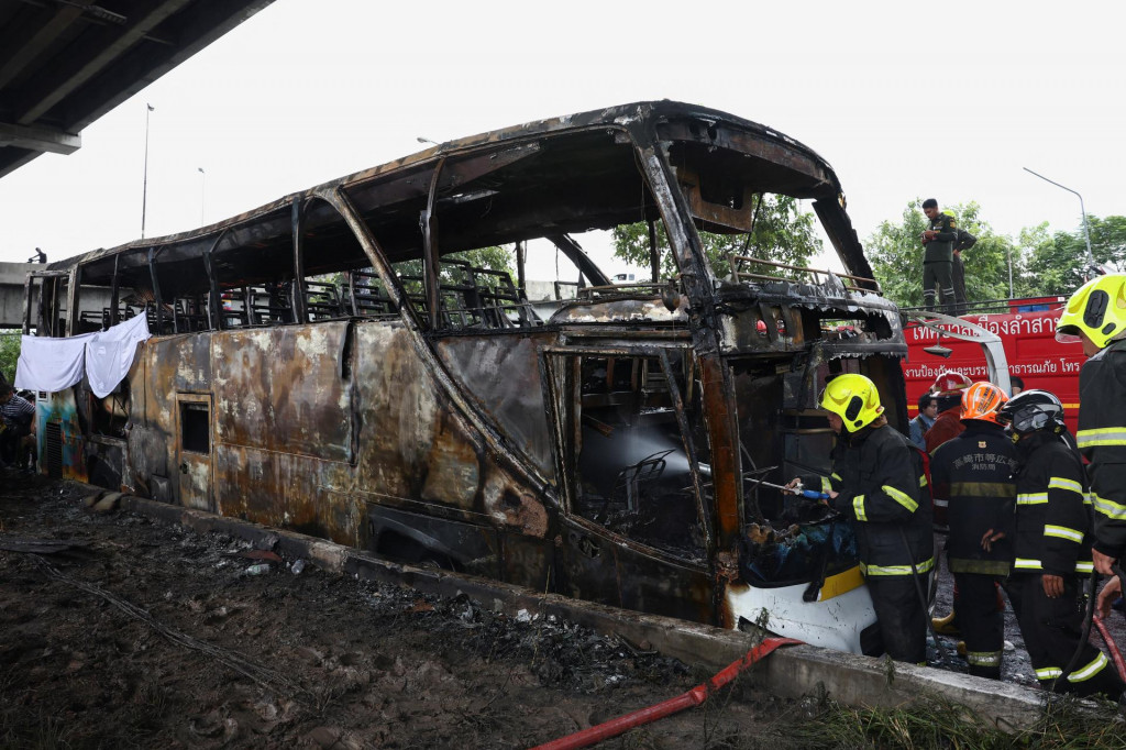 Hasiči pracujú na uhasení horiaceho autobusu, ktorý viezol učiteľov a študentov. FOTO: Reuters