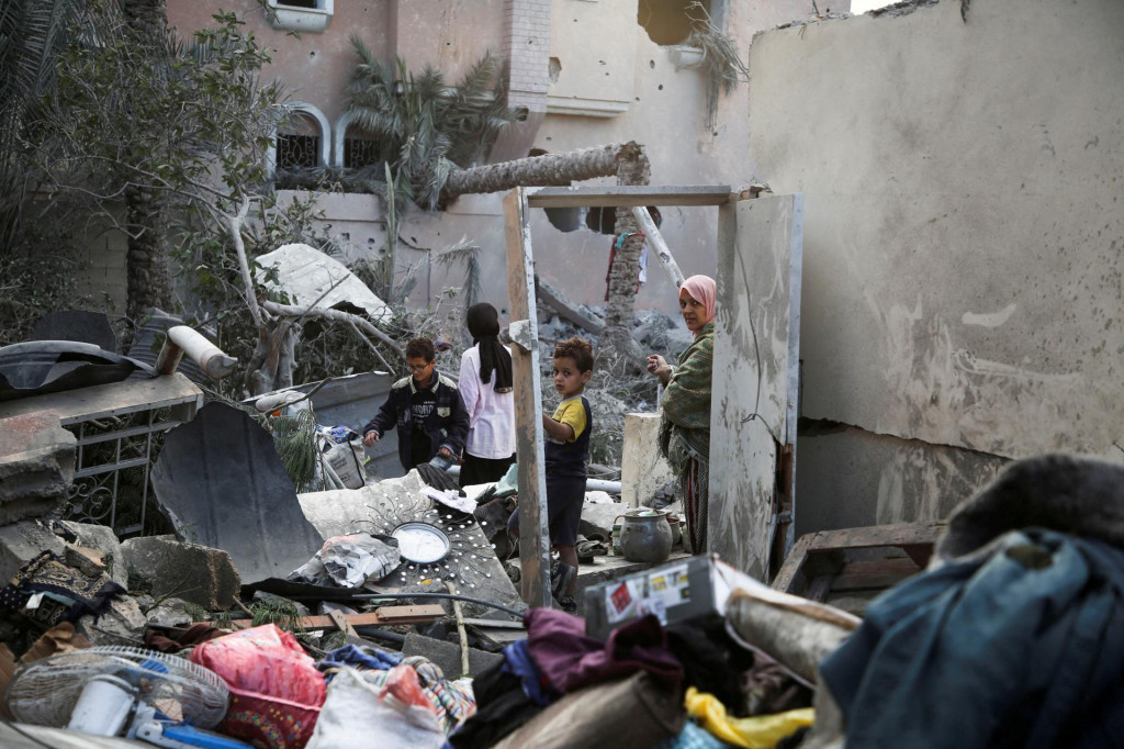 Palestínčania kontrolujú miesto izraelských útokov na domy uprostred konfliktu medzi Izraelom a Hamasom v meste Chán Júnis​ v južnom Pásme Gazy. FOTO: Reuters