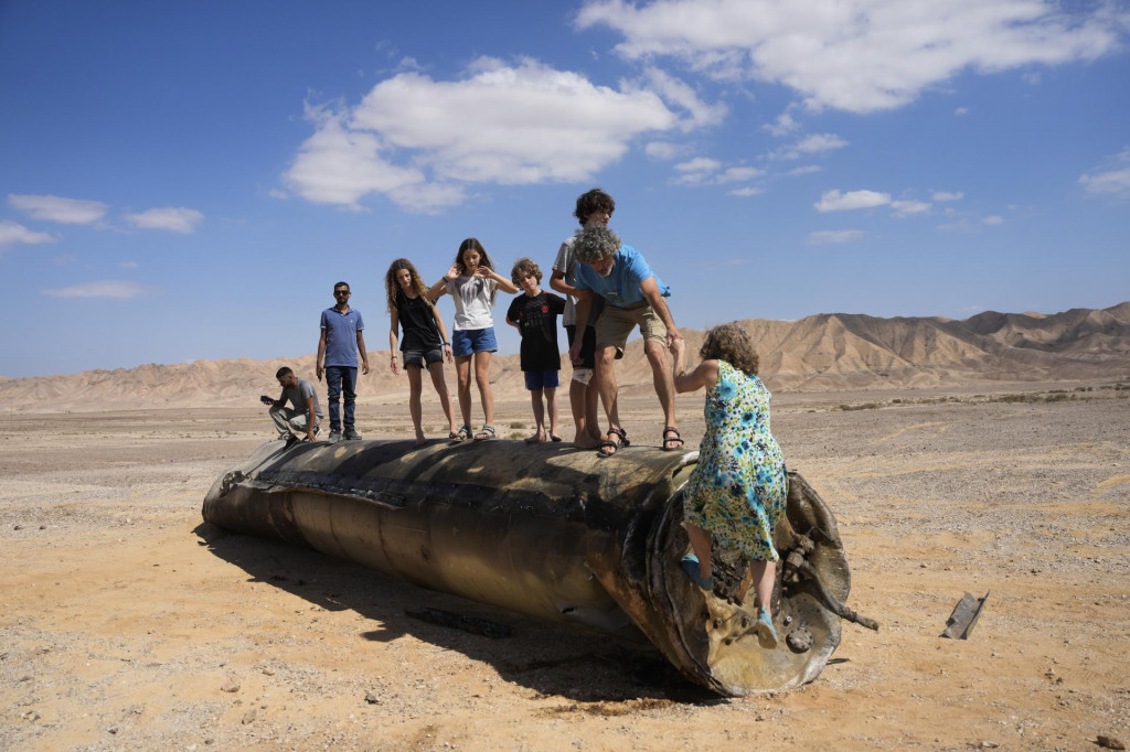 Ľudia pri meste Arad lezú na trosky rakety po iránskom útoku na Izrael. FOTO: TASR/AP
