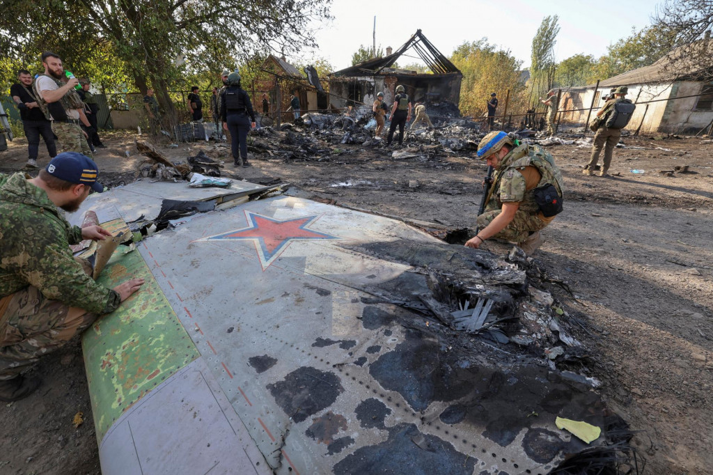 Príslušníci ukrajinskej služby kontrolujú časti ruského vzdušného dopravného prostriedku, o ktorom miestne úrady predpokladajú, že ide o najnovšie ťažké bezpilotné lietadlo S-70 Okhotnik (Hunter) alebo variáciu bojového lietadla Suchoj, ktoré bolo videné v obytnej štvrti mesta Kostintynivka po tom, ako bolo zostrelený v Doneckej oblasti na Ukrajine. FOTO: REUTERS