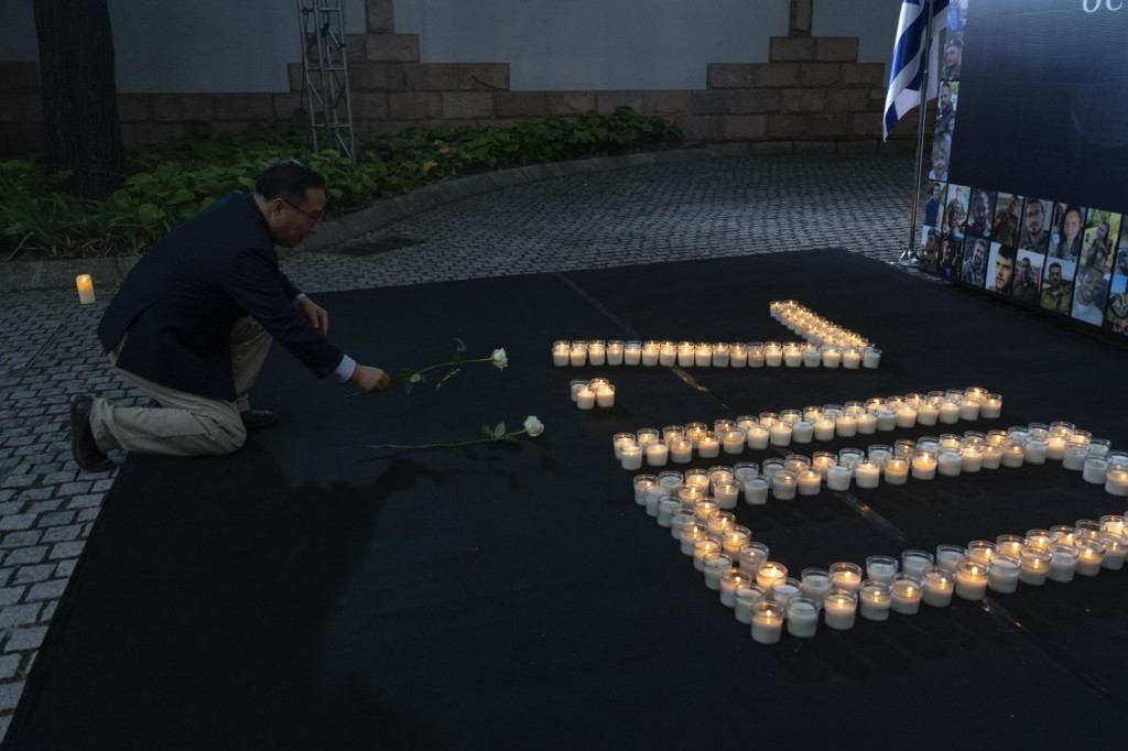 Čínsky komentátor Victor Gao kladie kvet na pamiatku obetí pri príležitosti prvého výročia teroristického útoku spáchaného palestínskym islamistickým hnutím Hamas na juhu Izraela v Pakingu. FOTO: TASR/AP