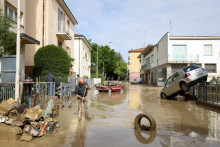 Obyvateľ odstraňuje blato a úlomky po silných dažďoch, ktoré zasiahli taliansky región Emilia Romagna, (18. mája 2023). FOTO: Reuters