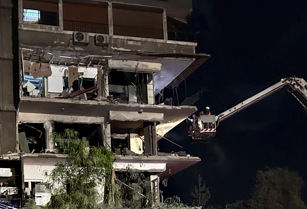 Záchranári na žeriave kontrolujú zničenú obytnú budovu po izraelskom leteckom útoku v sýrskom Damasku. FOTO: TASR/AP