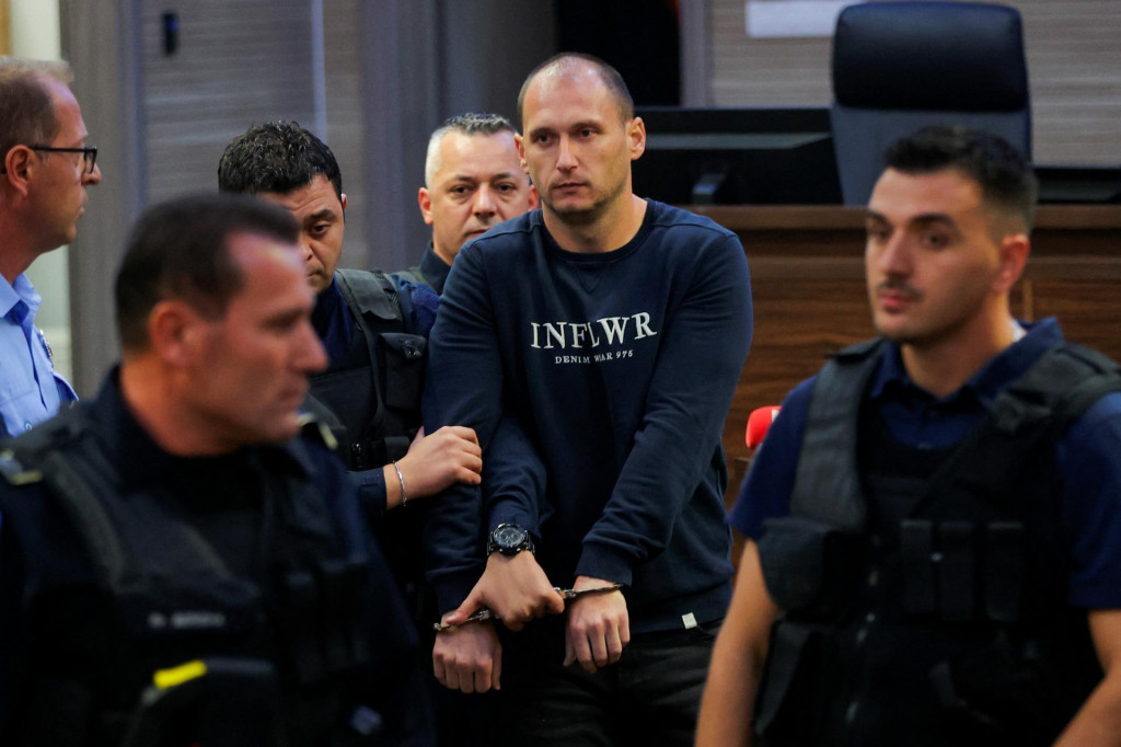 Kosovskí policajti eskortujú údajného srbského ozbrojenca do súdnej siene. FOTO: Reuters