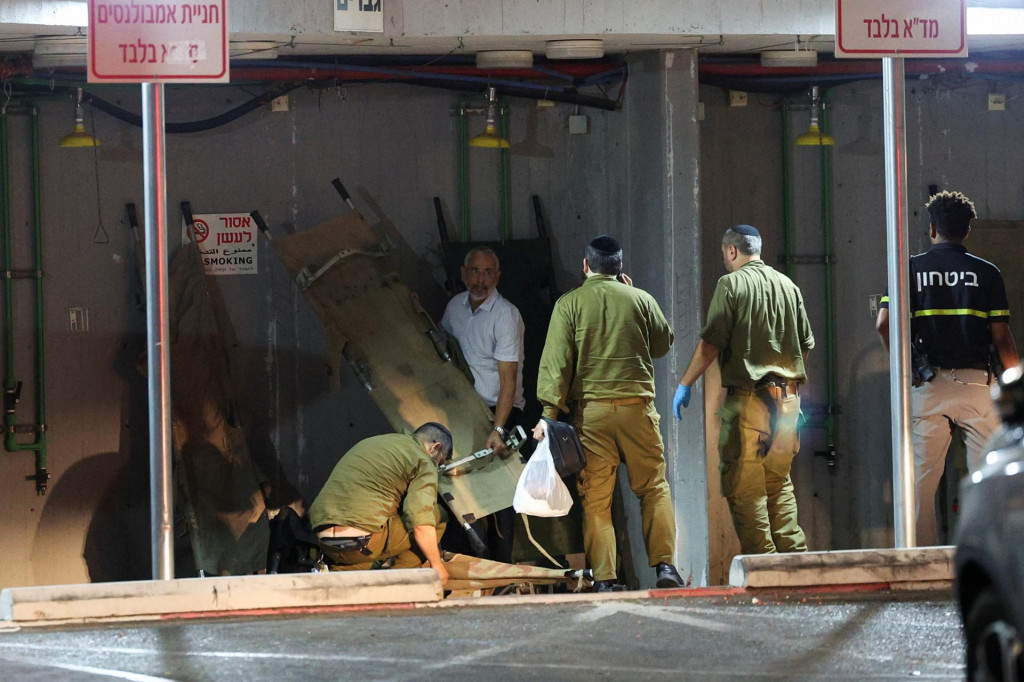 Izraelskí vojaci a ďalší ľudia po útoku bezpilotného lietadla z Libanonu zložili nosné vozíky. FOTO: Reuters