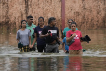 Ľudia sa brodia cez zaplavenú ulicu v meste Kolombo na Srí lanke v nedeľu 13. októbra 2024. FOTO: TASR/AP