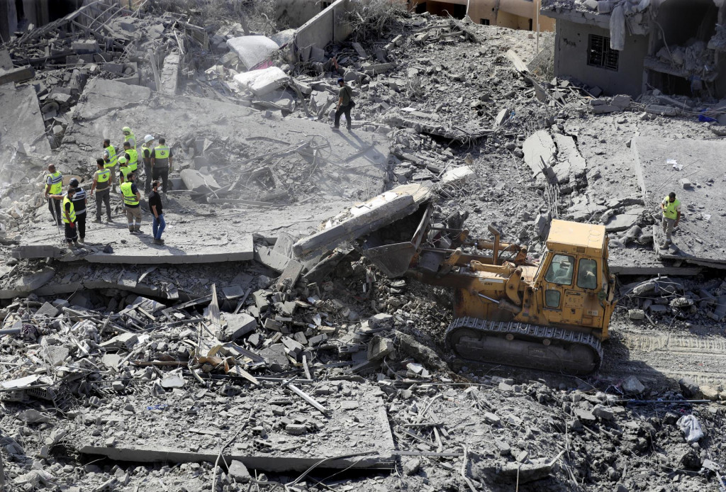 Záchranári pomocou buldozéru prehľadávajú trosky zničených obytných budov po izraelskom leteckom útoku v dedine Kaná, na juhu Libanonu. FOTO: TASR/AP