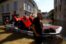 Francúzski hasiči evakuujú obyvateľov loďou zo zaplavenej oblasti v Crecy-la-Chapelle v departemente Seine-et-Marne po tom, čo silný dážď a prechod búrky Kirk spôsobili záplavy. FOTO: Reuters