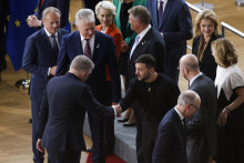 Ukrajinský prezident Volodymyr Zelenskyj (uprostred) a slovenský premiér Robert Fico si podávajú ruky počas spoločného fotenia pred samitom EÚ v Bruseli. FOTO: TASR/AP