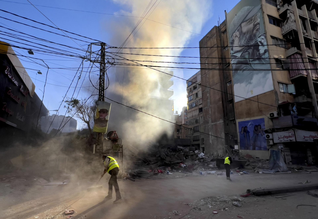 Zamestnanci upratujú ulicu neďaleko obrovského portrétu zosnulého vojenského veliteľa libanonského militantného hnutia Hizballáh Imáda Mugníju. FOTO TASR/AP
