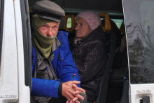 Miestny muž sa pozerá z dobrovoľníckeho autobusu, ktorý čaká na evakuáciu z mesta Kupiansk z frontovej línie v Charkovskej oblasti na Ukrajine. FOTO: REUTERS