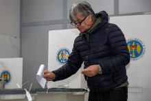 Volič v Kišiňove odovzdáva hlas vo volebnej miestnosti pošas prezidentských voieb a referenda o vstupe do Európskej únie. FOTO: Reuters