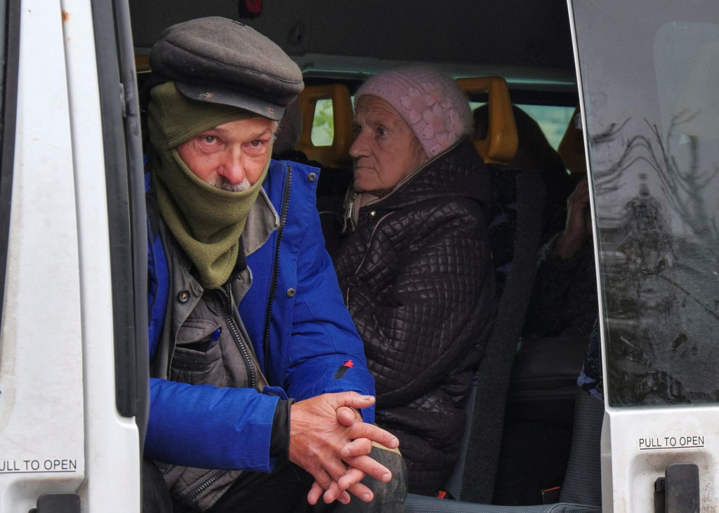 Miestny muž sa pozerá z dobrovoľníckeho autobusu, ktorý čaká na evakuáciu z mesta Kupiansk z frontovej línie v Charkovskej oblasti na Ukrajine. FOTO: REUTERS