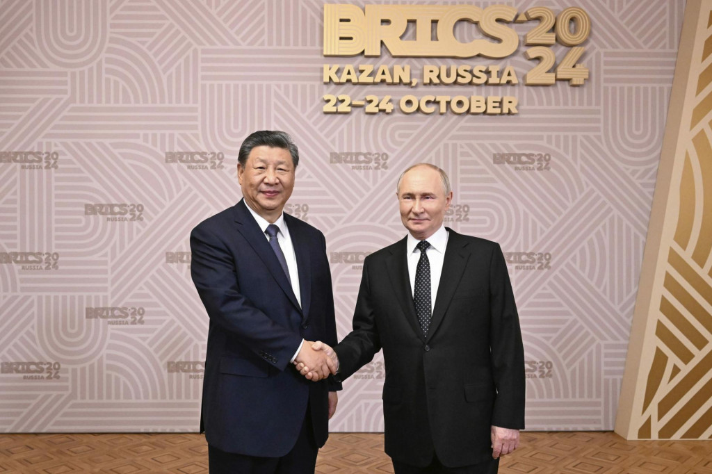 Na tejto fotografii zverejnenej tlačovou agentúrou Xinhua si ruský prezident Vladimir Putin vpravo a čínsky prezident Si Ťin-pching podávajú ruky pred uvítacím banketom na summit BRICS v Kazani. FOTO: TASR/AP