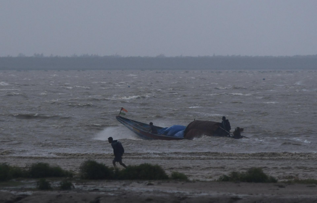 Rybári sa pokúšajú priviesť svoju loď späť na breh počas prílivu predtým, ako cyklón Dana dopadne na pevninu v indickom štáte Urísa. FOTO: Reuters