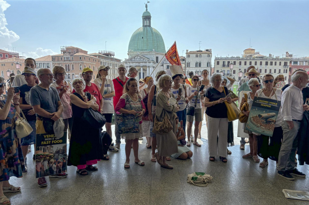 Na archívnej snímke z 13. júla 2024 sa aktivisti zhromažďujú pred benátskou železničnou stanicou Santa Lucia, aby protestovali proti poplatkom pre jednodňových turistov. FOTO: TASR/AP