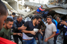 Palestínčanovi sa poskytuje pomoc na mieste izraelského útoku na dom uprostred prebiehajúceho konfliktu medzi Izraelom a Hamasom. FOTO: Reuters