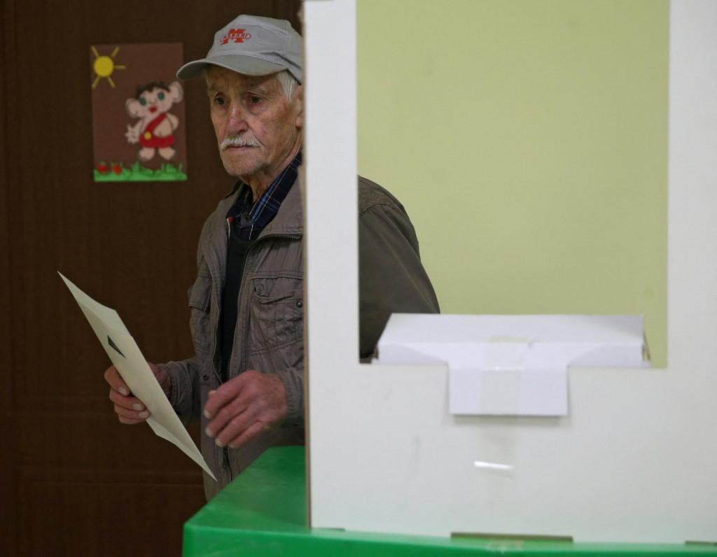 Volič pri odovzdávaní hlasu počas parlamentných volieb do volebnej miestnosti v Tbilisi. FOTO: Reuters