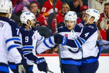 Center Winnipegu Jets Cole Perfetti (91) oslavuje so spoluhráčmi gól proti Calgary Flames počas tretej tretiny v Scotiabank Saddledome. FOTO: Sergei Belski/Imagn Images