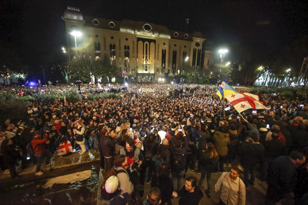 Demonštranti mávajú gruzínskymi a ukrajinskými vlajkami pred gruzínskom parlamentom. FOTO TASR/AP